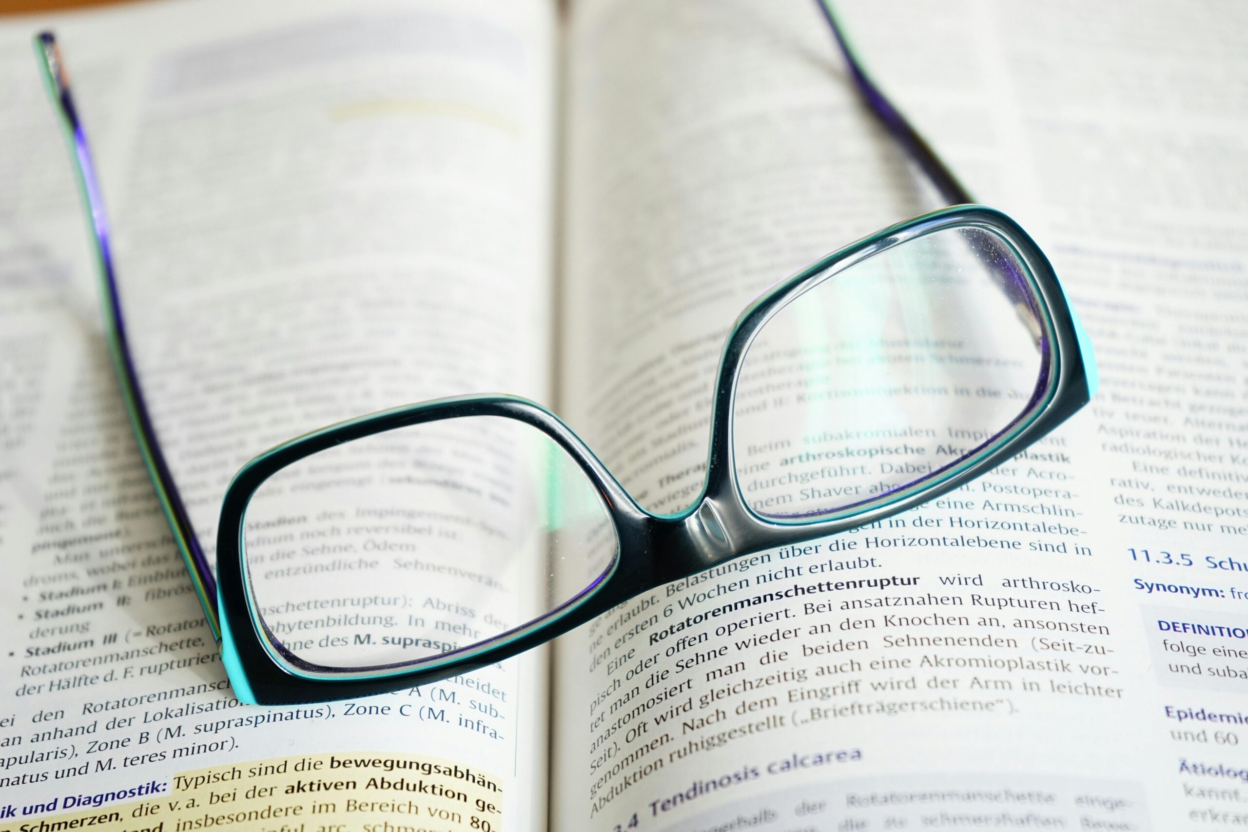 Reading glasses resting on an open textbook, symbolizing study and knowledge.